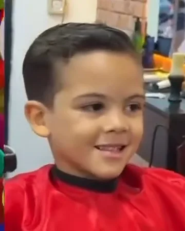 Menino sorrindo com corte social recém-feito