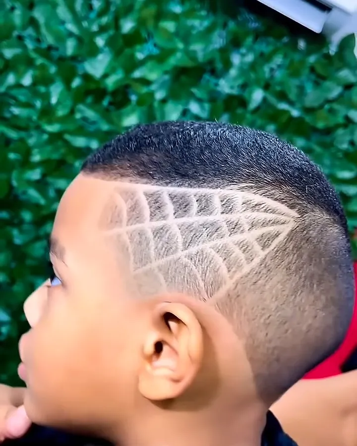 Menino com freestyle de teia de aranha na lateral do cabelo