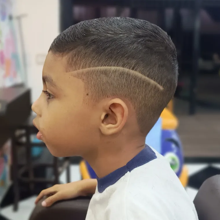 Menino de perfil com degradê e risco lateral