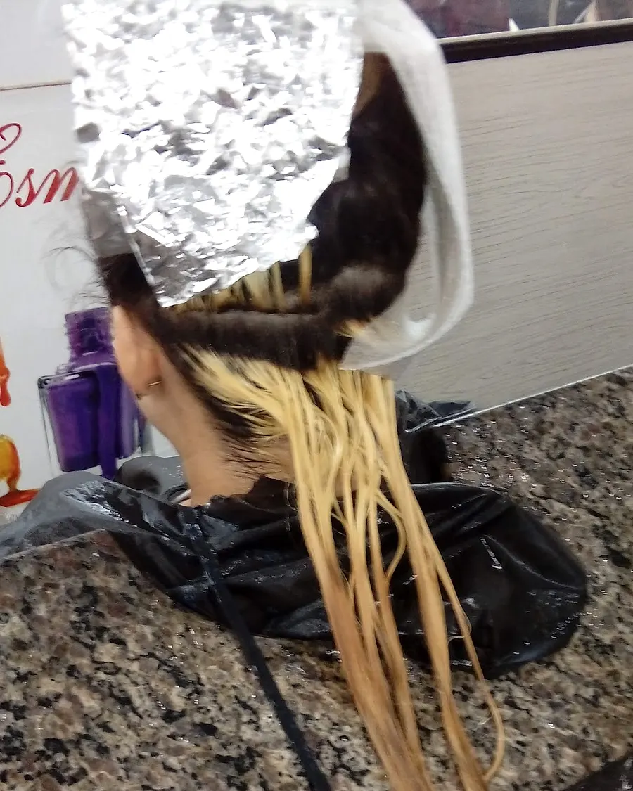 Mechas sendo feitas com papel alumínio no lavatório
