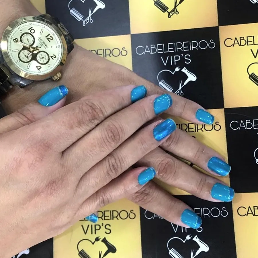 Unhas pintadas de azul com detalhe decorado